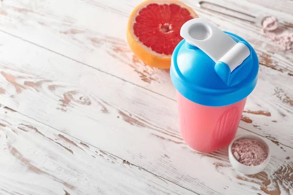 Bottle of protein shake on white wooden table — Stock Photo, Image