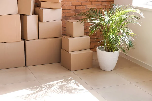 Mover cajas cerca de la pared de ladrillo en la habitación —  Fotos de Stock