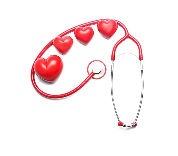 Estetoscopio y corazones rojos sobre fondo blanco. Concepto de cardiología — Foto de Stock