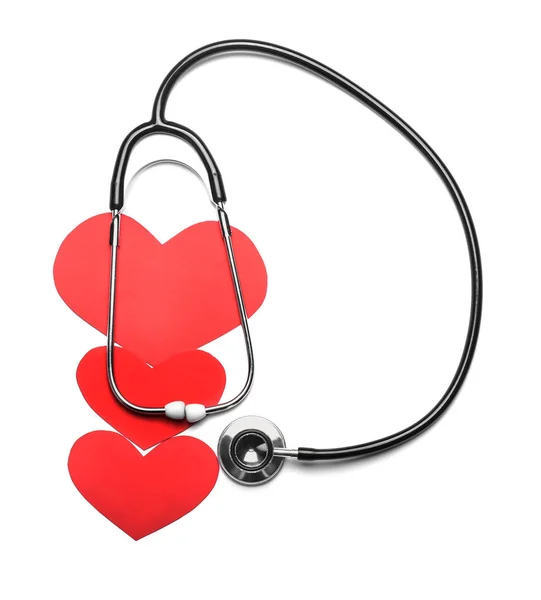 Стетоскоп и красные сердца на белом фоне. Концепция кардиологии — стоковое фото