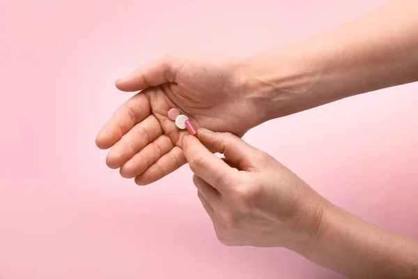 Manos femeninas con pastillas sobre fondo de color —  Fotos de Stock
