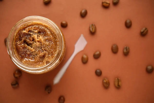 Jar of coffee sugar scrub on color background