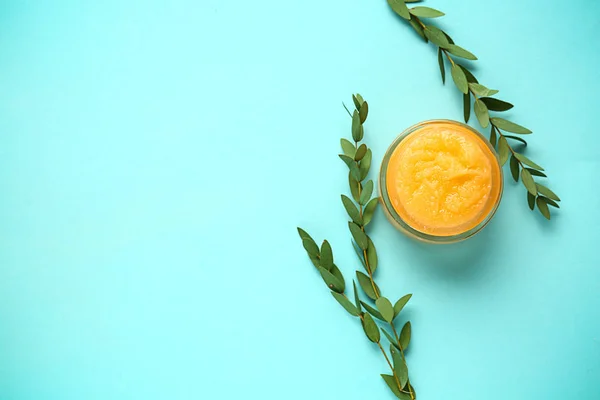 Jar of sugar scrub on color background