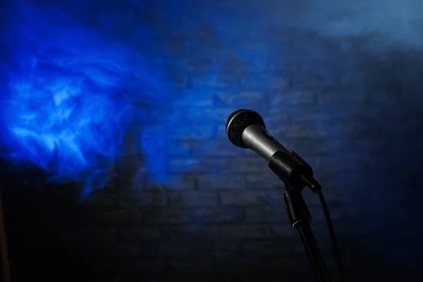 Moderne microfoon in rook op het podium — Stockfoto