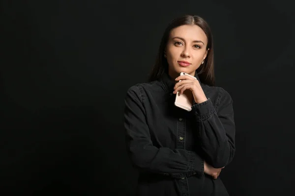 Stylish businesswoman with mobile phone on dark background — Stock Photo, Image