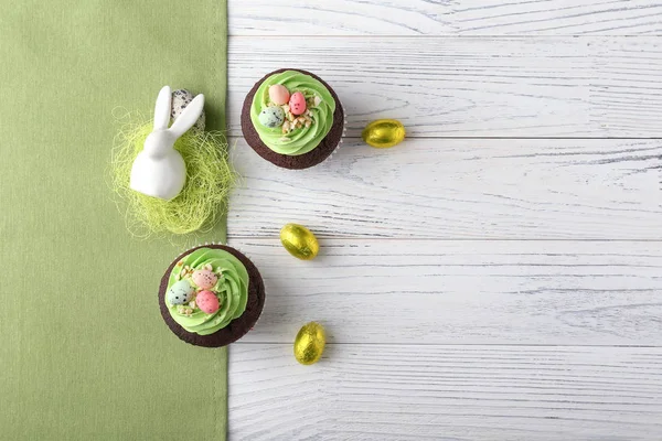 Tasty Easter cupcakes with candies on white table — Stock Photo, Image