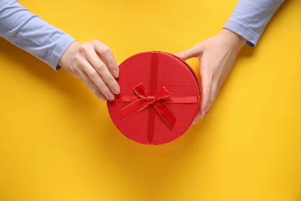 Female hands with gift box on color background — Stock Photo, Image