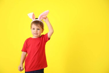 Paskalya yumurtası ve tavşan kulakları renk arka plan üzerinde şirin küçük çocuk