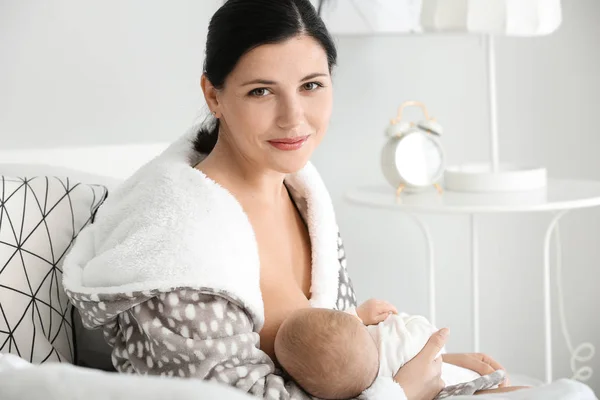 Young woman breastfeeding her baby at home — Stock Photo, Image