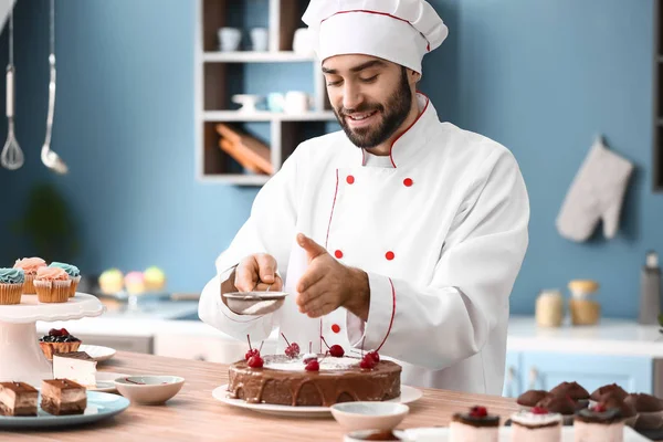 Mužské cukrář zdobení chutné čokoládový dort v kuchyni — Stock fotografie