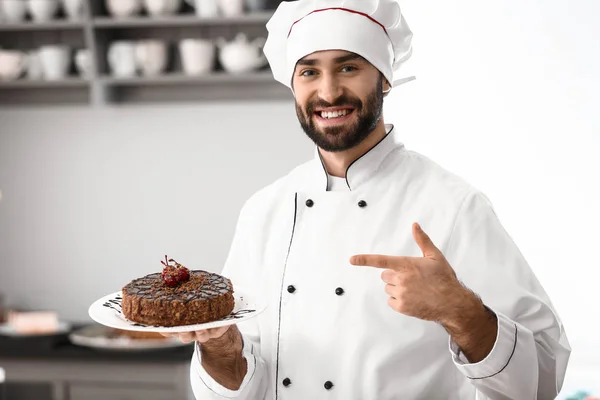 Mužské cukrář s chutný čokoládový dort v kuchyni — Stock fotografie