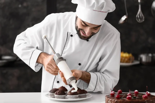 Mužské cukrář vaření chutné koláčky v kuchyni — Stock fotografie