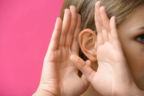 Young woman with hearing problem on color background, closeup