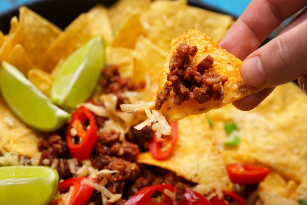 Femme mangeant des nachos savoureux avec de la viande hachée, gros plan — Photo