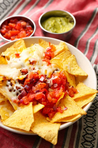 Prato com nachos saborosos, queijo, carne picada e salsa na mesa — Fotografia de Stock