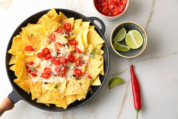Serpenyőben, ízletes nachos, a sajt és a chili, a fény asztal — Stock Fotó