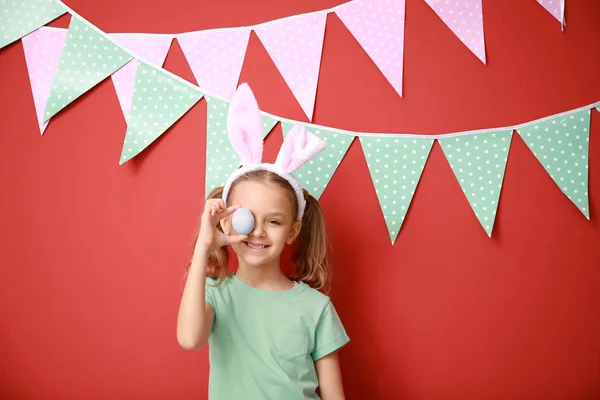 Paskalya yumurtası ve dekore edilmiş renk duvarının yakınında tavşan kulakları ile sevimli küçük kız — Stok fotoğraf