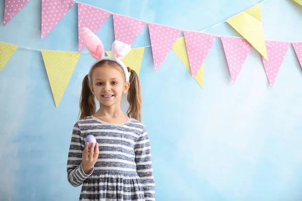 부활절 계란과 컬러 장식 벽 근처 토끼 귀를 가진 귀여운 어린 소녀 — 스톡 사진