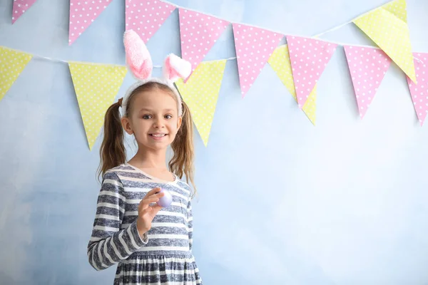 부활절 계란과 컬러 장식 벽 근처 토끼 귀를 가진 귀여운 어린 소녀 — 스톡 사진