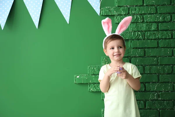 可爱的小男孩与复活节彩蛋和兔子耳朵附近的颜色装饰墙 — 图库照片