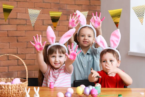 Niedliche kleine Kinder mit schmutzigen Händen nach dem Bemalen von Ostereiern zu Hause — Stockfoto