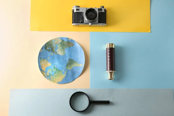 Paper Earth, photo camera, spyglass and magnifier on color background. Travel concept — Stock Photo, Image