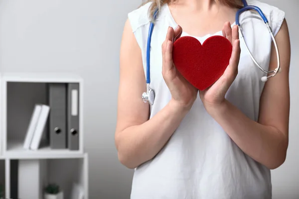 Woman with red heart in clinic — Stock Photo, Image