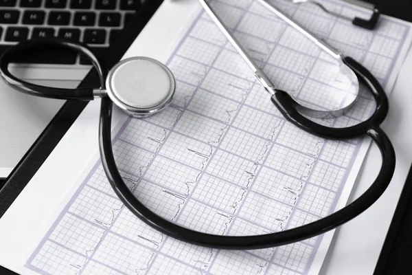 Estetoscópio e cardiograma na mesa na clínica — Fotografia de Stock