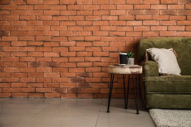 Tuğla duvara yakın kanepe ve masa