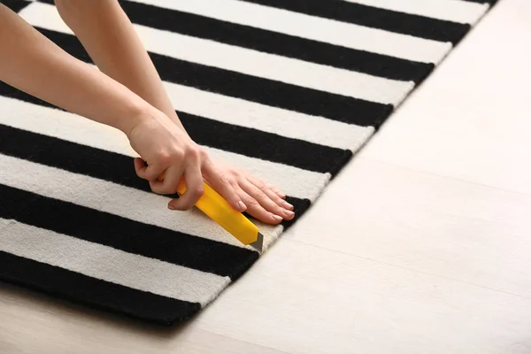 Kobieta cięcia dywan w domu — Zdjęcie stockowe