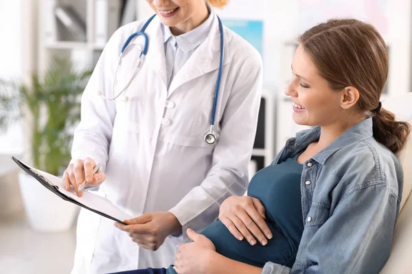 Young pregnant woman visiting her gynecologist in clinic — Stock Photo, Image