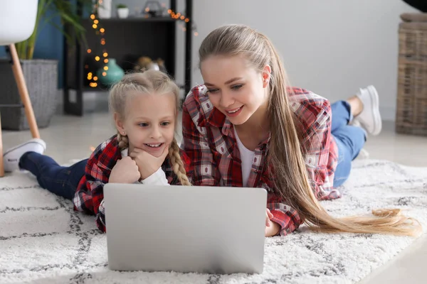 Young mother with little daughter watching cartoons at home — Stock Photo, Image