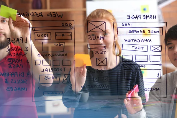 IT designers discussing project, view through transparent board — Stock Photo, Image