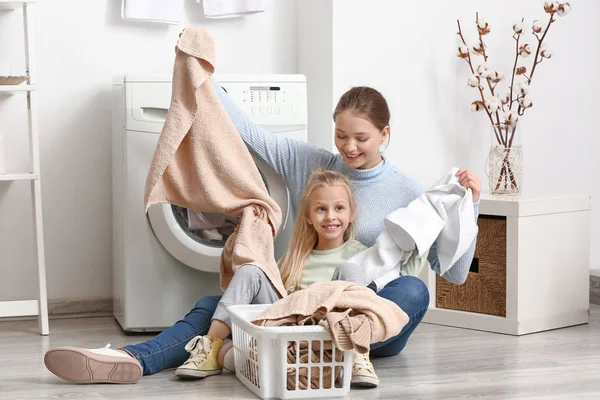 Jeune femme et sa petite fille faisant la lessive à la maison — Photo