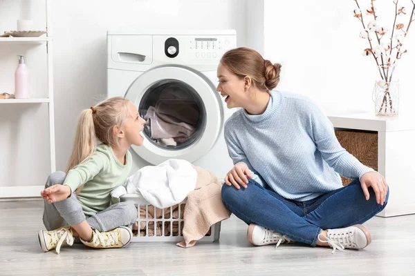 Mujer joven y su hija pequeña jugando en casa el día de la colada — Foto de Stock