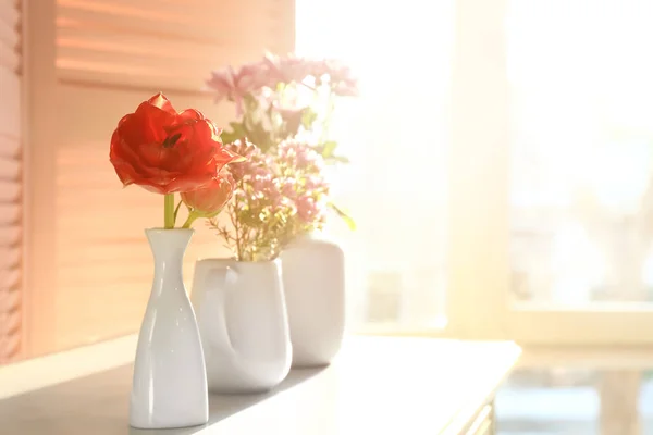 Vázák, gyönyörű virágok a szobában asztal — Stock Fotó