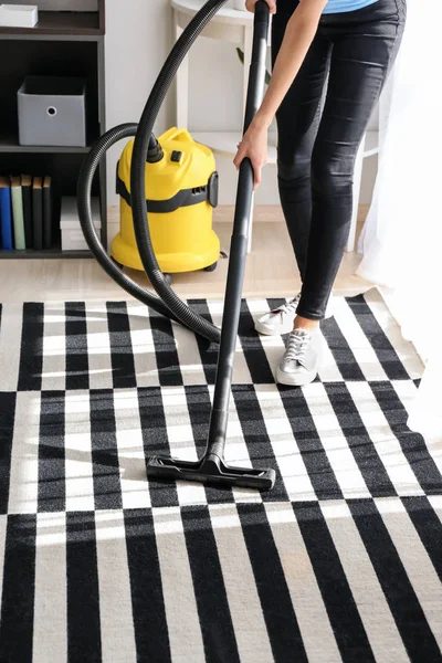 Woman hoovering carpet in flat — Stock Photo, Image