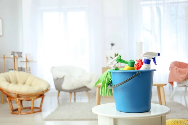 Balde com material de limpeza na mesa em casa — Fotografia de Stock