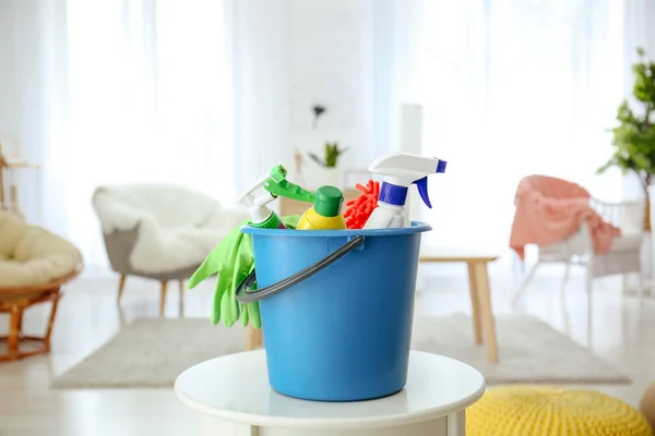 Bucket with cleaning supplies on table at home — Stock Photo, Image