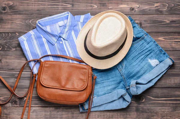 Roupas femininas com chapéu e saco em fundo de madeira — Fotografia de Stock