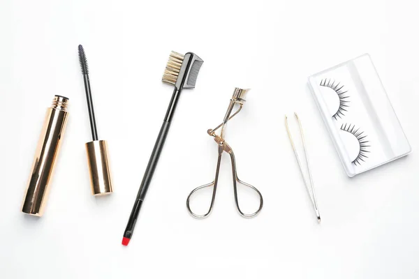 Wimperntusche mit falschen Wimpern und Werkzeugen auf weißem Hintergrund — Stockfoto