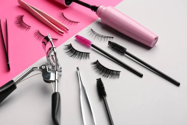 Mascara with false eyelashes and tools on color background — Stock Photo, Image