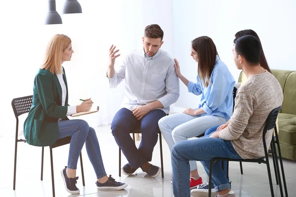 Personas calmando al hombre en la sesión de terapia de grupo — Foto de Stock