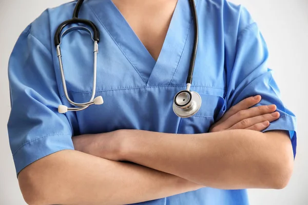 Doctor with stethoscope on light background, closeup — Stock Photo, Image