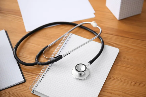 Stethoscope with notebook on doctor\'s table