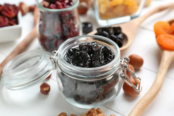 Jar met smakelijke gedroogde pruimen op witte tafel — Stockfoto