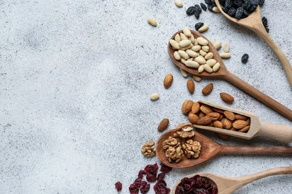 Surtido de sabrosos frutos secos y frutos secos sobre fondo gris — Foto de Stock