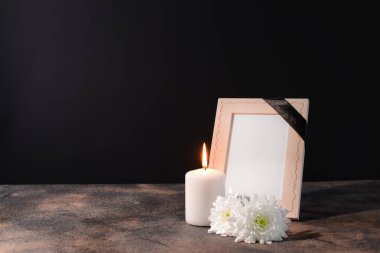 Boş cenaze çerçeve, mum ve siyah arka plan masaya çiçek