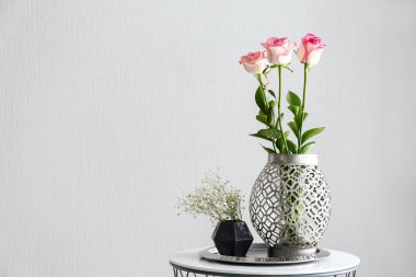 Beyaz arka plan karşı masada güzel çiçekli vazo