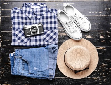 Koyu ahşap arka plan üzerinde kamera şapka ve fotoğraf Bayan giyim